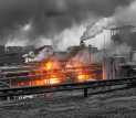 Incendio en una instalación industrial con llamas y una gran columna de humo.