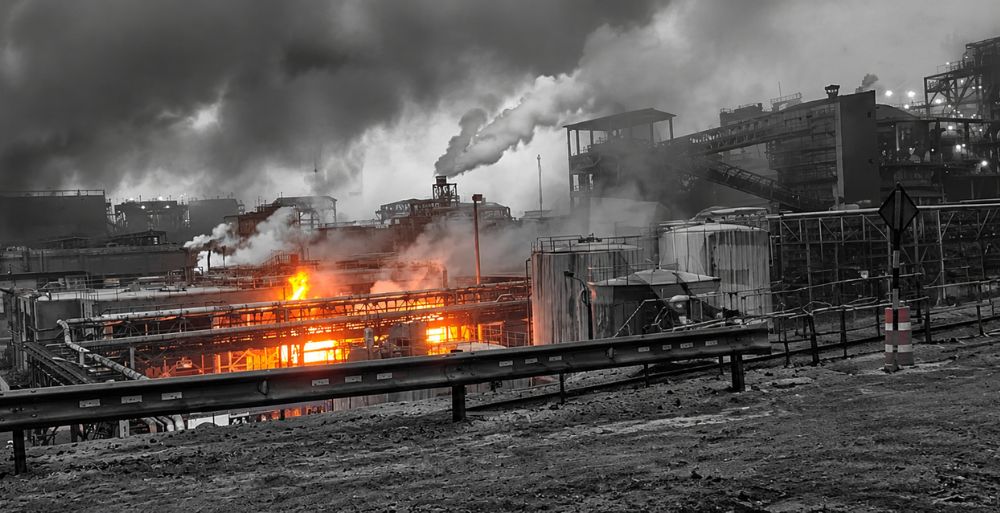 Incendio en una instalación industrial con llamas y una gran columna de humo.