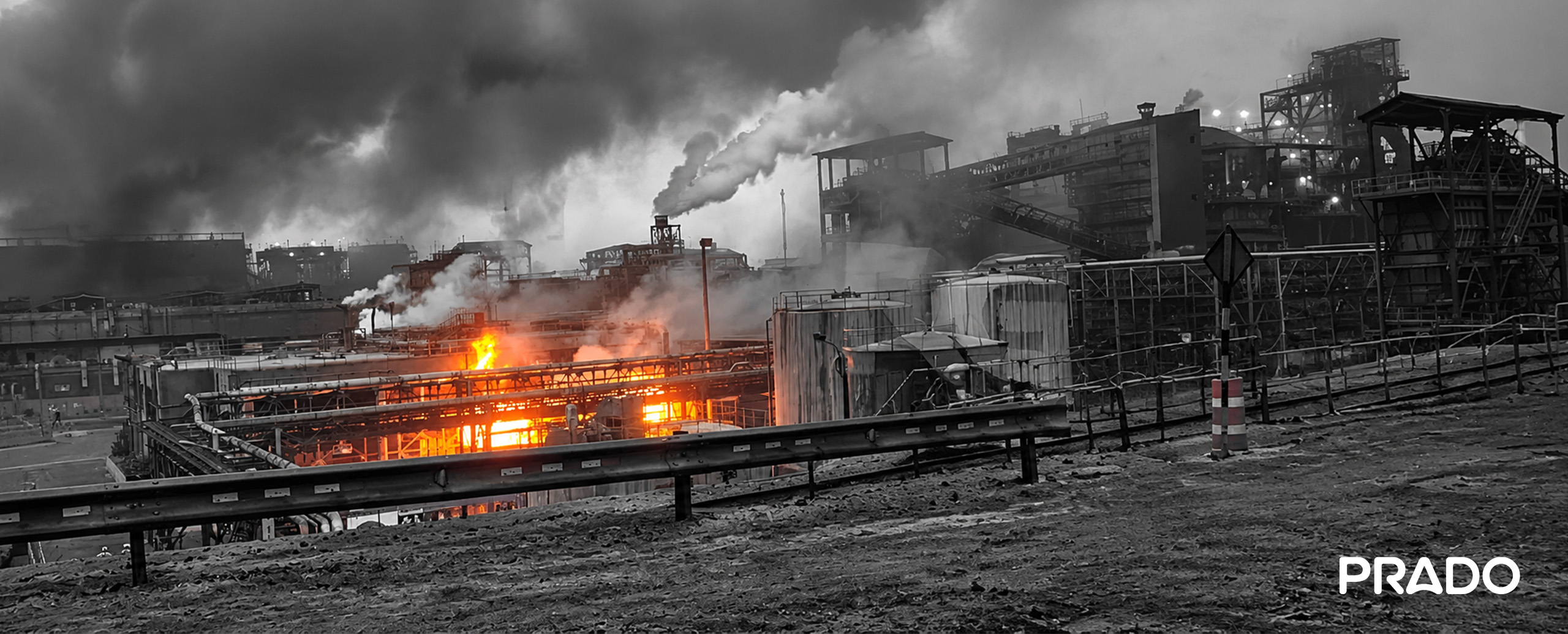 Incendio en una instalación industrial con llamas y una gran columna de humo.