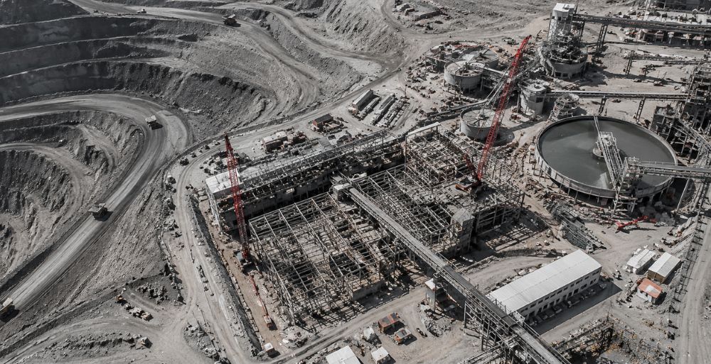 Vista aérea de un proyecto minero con instalaciones industriales en construcción.